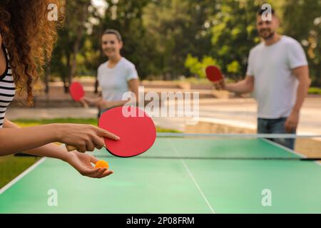 Freunde, die im Freien Tischtennis spielen, konzentrieren sich auf die Hände Stockfoto