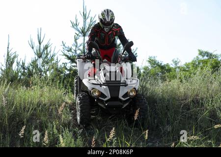 Mann, der ein modernes Quad im Freien fährt. Extremsport Stockfoto