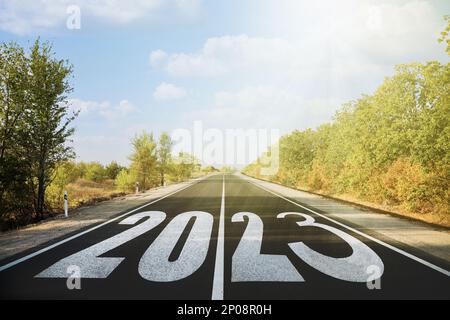 Beginnen Sie das neue Jahr mit neuen Visionen und Ideen. 2023 Nummern auf Asphaltstraße Stockfoto