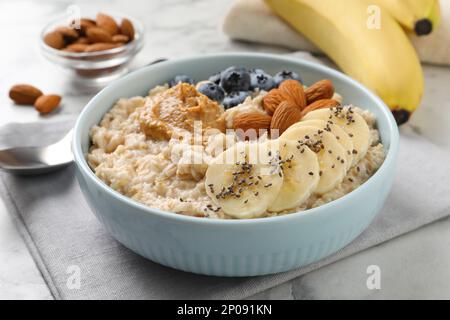 Leckerer Haferbrei mit Belägen auf dem Tisch Stockfoto