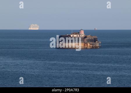 Ein Blick auf die Sonne - No man's Land Fort im Vordergrund, während Sie am Horizont sind, das Kreuzfahrtschiff „Enchanted Princess“ und der NAB-Turm vom 2022. August. Stockfoto