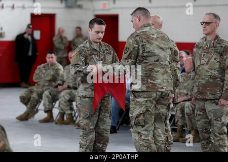 Das letzte Kommando-Team der 171. Engineer Company, Kapitän Micheal Haugh, Left, und 1. Sergeant Andrew Crouse, rollte feierlich den Guidon der Einheit bei einer Zeremonie in der Waffenkammer der North Carolina National Guard (NCNG) in St. Pauls, North Carolina, 7. Januar 2023. Die Zeremonie war Ende der 171. Jahre, als die NCNG umstrukturierte und sich an die Bedürfnisse der Armee anpasste. Stockfoto