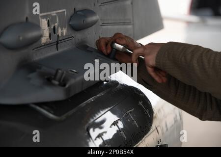 Airman 1. Class Jared Norton, 480. Expeditionary Fighter Squadron Crew Chief, entfernt eine Reisekapsel aus einem F-16cm Fighting Falcon, der dem 52. Fighter Wing, Spangdahlem Air Base, Deutschland, zugewiesen wurde, nach Ankunft am Kadena Air Base, Japan, 16. Januar 2023. Die F-16 ist ein äußerst manövrierfähiges, multifunktionales Kampfflugzeug und hat sich im Luft-Luft-Kampf und in der Luft-zu-Boden-Verteidigung bewährt. Stockfoto