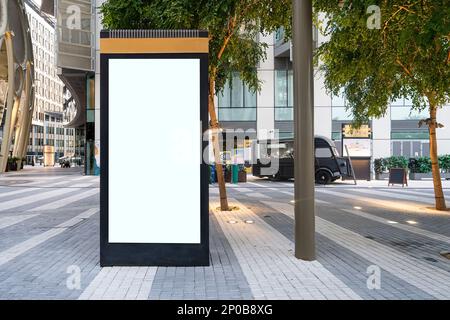 Leeres Modell einer vertikalen Plakatwand im Stadthintergrund. Elektronische moderne leere Anzeigetafel im Hintergrund einer Stadtstraße. Kopieren Sie Spac Stockfoto