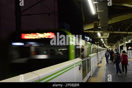 Japanische Passagiere warten auf die JR Yamanote-Linie in Tokio, Japan. Stockfoto