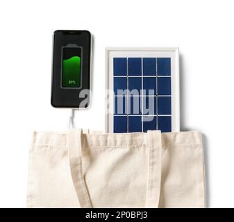 Tasche mit tragbarem Solarmodul zum Aufladen des Mobiltelefons auf weißem Hintergrund, Nahaufnahme Stockfoto