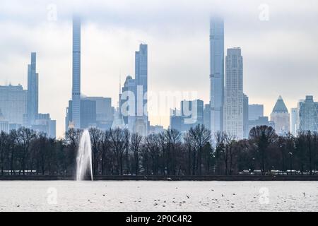 New York, 2. März 2023. Blick auf die Skyline von New York City vom Jacqueline Kennedy Onassis Reservoir im Central Park in einem bewölkten Nachterno im Winter Stockfoto