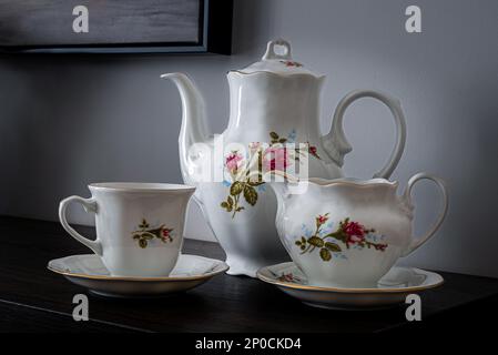 Porzellangeschirr, Kaffee- oder Teetasse. Tee- oder Kaffeekanne und Zuckerdose. Handbemalte Blumen. Kann zur Veranschaulichung von Porzellan in Zeitungen verwendet werden. Stockfoto