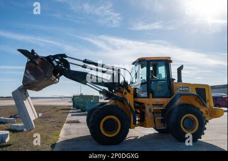 EIN US-AMERIKANISCHER Air Force Airman, dem 202. RED HORSE Squadron zugeteilt, Florida Air National Guard, verwendet einen Kompaktlader, um eine Betonplatte von der Rampe am Naval Air Station Jacksonville, Florida, am 7. Februar 2023 zu entfernen. Die Airmen renovieren den Flugplatz, um sicherzustellen, dass Rollbeton dem Gewicht der USA standhalten kann Die P-8A Poseidon-Maschine der Navy. Stockfoto