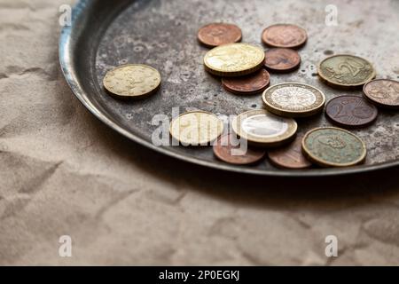 Einige Euro-Münzen auf einem Teller in der Nähe verstreut. Verschiedene Geld der Europäischen Union. Flache Fokus Stockfoto