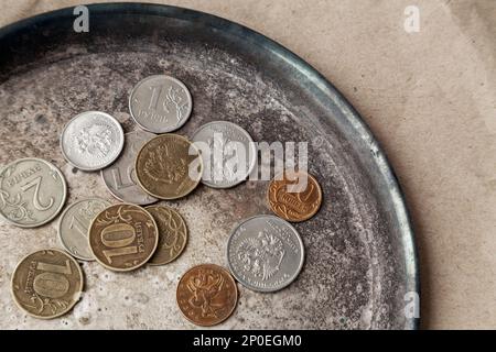 Einige russische Münzen auf einem Teller in der Nähe verstreut. Verschiedene Geld von Russland mit der Adler der Ansicht von oben Stockfoto