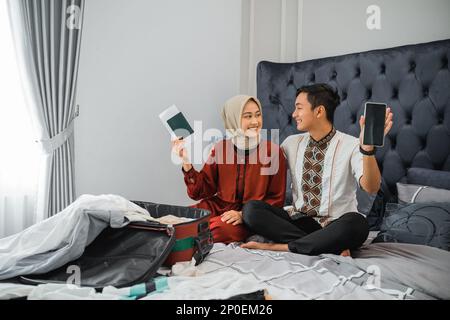 Muslimisches Paar mit Passkarten und Handybildschirmen Stockfoto