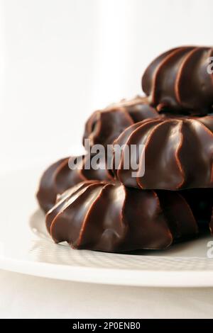 Haufen von Marshmallows mit Schokolade glasiert. Viele beschichtet elegante Zephyr Dessert isoliert auf weiss. Elegante Süßspeise auf einem Teller Stockfoto