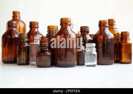 Gruppe von verschiedenen medizinischen Durchstechflaschen auf Weiß isoliert. Viele kleine braune Flaschen ohne Etiketten Stockfoto