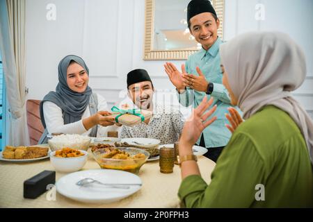 Die Frau schenkt einem Freund ein Geschenk, bevor sie das Fasten bricht Stockfoto