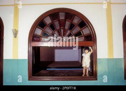 Ein Mädchen, das in Moplah am Fenster steht, ein muslimisches Kerala-Haus in Kozhikode, Calicut, Kerala, Indien Stockfoto