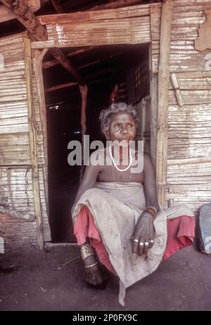 Mudunga-Stammes alte Dame, die vor der Hütte sitzt, ein Stammesdorf in der Nähe von Silent Valley, Kerala, Indien Stockfoto