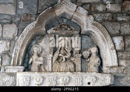 Szene aus dem 15. Jahrhundert mit Madonna und Kind, flankiert von St. Tryphon und St. Bernard beim Eintritt durch das Seetor in die Altstadt von Kotor, Montenegro Stockfoto