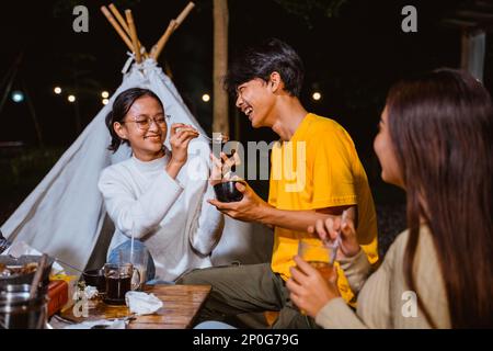 Eine Frau in einem weißen Strickpullover, die den Kerl füttert Stockfoto