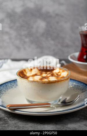 Reispudding. Traditionelle türkische Küche als Desserts. Reispudding Dessert mit Milch, Zucker und Reis auf dunklem Hintergrund. Schließen Stockfoto