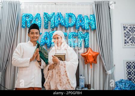 ein asiatisches muslimisches Paar wünscht sich einen glücklichen ramadan mit Handgesten Stockfoto