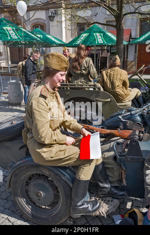 Reenaktorin in sowjetischer Uniform, mit polnischer Flagge, vor der Wiederaufnahme der Schlacht von WW2, Rathausplatz in Jelenia Gora, Niederschlesien, Polen Stockfoto