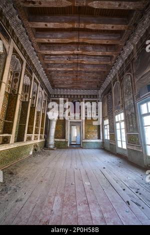 Blick auf ein verlassenes Bauwerk, das jetzt größtenteils ruiniert ist und auf die Restaurierung wartet. Das große, zentrale Wohnzimmer mit Metallheizung. Bei einem Stockfoto