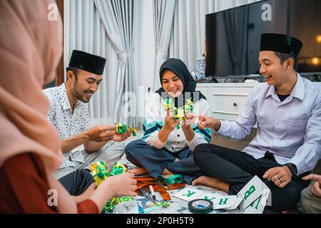 Asiatisch-muslimische Freundschaft stellt dekorative Eid-Ornamente gewebtes Ketupat her Stockfoto