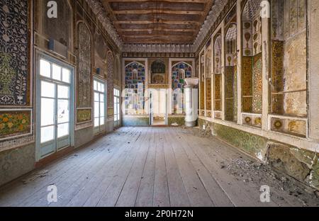 Blick auf ein verlassenes Bauwerk, das jetzt größtenteils ruiniert ist und auf die Restaurierung wartet. Das große, zentrale Wohnzimmer mit Metallheizung. Bei einem Stockfoto