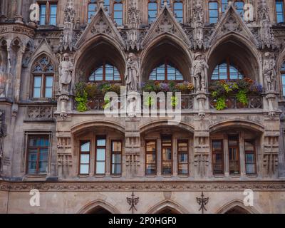 Fassade des neogotischen Rathauses mit täglichen Aufführungen zum Glockengeräusch und einem hohen Turm mit Blick auf die Stadt am Marienplatz München Stockfoto