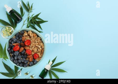 CBD-Öl, THC-Tinktur, Hafermehlschale und Hanfblätter auf hellblauem Hintergrund, flach gelegt. Platz für Text Stockfoto