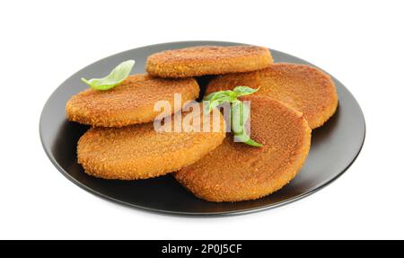 Köstliche gebratene panierte Schnitzel mit Basilikumblättern auf weiß isoliert Stockfoto