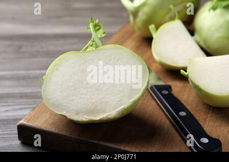 Ganze und geschnittene Kohlrabi-Pflanzen auf Holztisch, Nahaufnahme Stockfoto