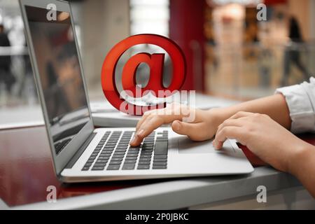 Eine Frau, die E-Mails per Laptop im Café verschickt Stockfoto