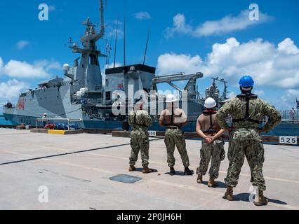 DIEGO GARCIA, Britisches Territorium im Indischen Ozean – Matrosen, die den USA zugeteilt sind Marinesupport-Einrichtung Diego Garcia beobachtet HMS Tamar (P233), das vierte der fünf von der Royal Navy betriebenen Chargen-2-Offshore-Patrouillenschiffe der Flussklasse, trifft in Diego Garcia ein, um einen planmäßigen Hafenbesuch am 15. Februar 2023 zu machen. Der Besuch unterstrich die strategische Bedeutung von Diego Garcia für ein dauerhaft freies und offenes Indo-Pacific, indem er Präsenz ermöglicht, den Zugang sicherstellt und das globale Gemeingut verteidigt. Stockfoto