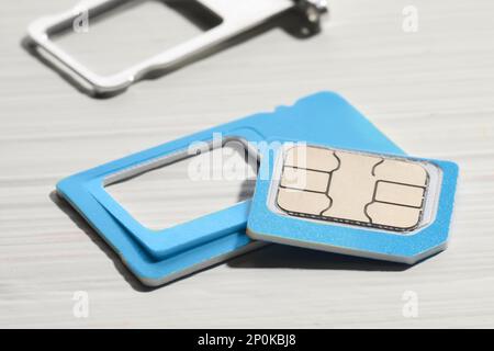 Multi-SIM-Karte auf weißem Holzhintergrund, Nahaufnahme Stockfoto