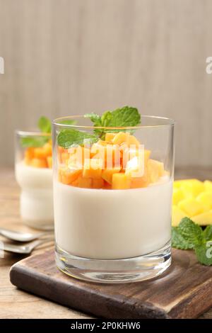 Köstliches Panna Cotta mit Mango auf einem Holztisch Stockfoto