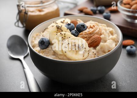 Leckerer Haferbrei mit Belägen, serviert auf dem Tisch, Nahaufnahme Stockfoto