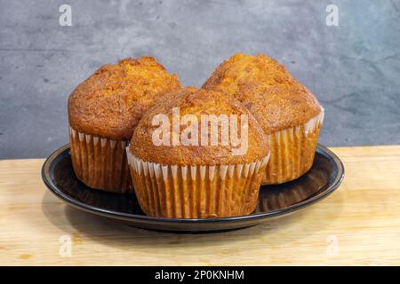 Bananentörtchen auf einem Holzbrett, hausgemachte Bananen leckere Obstbäckerei. Stockfoto