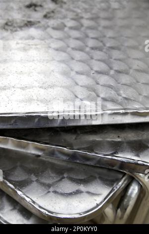 Details nasser Metalltische an einem kalten Regentag auf der Straße Stockfoto