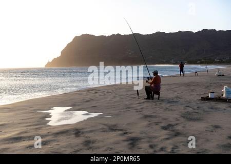 Angeln bei Sonnenuntergang an einem wunderschönen Sandstrand in der Nähe des Fischerdorfs, der Insel Sao Vicente und Cabo verde Stockfoto