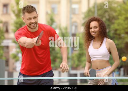 Freunde spielen im Freien Tischtennis am Sommertag Stockfoto