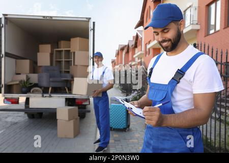 Transport von Servicemitarbeitern ins Freie, Entladen von Kisten und Checkliste Stockfoto