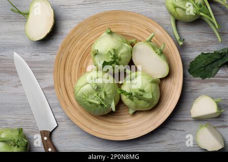 Ganze und geschnittene Kohlrabi-Pflanzen auf Holztisch, flach liegend Stockfoto