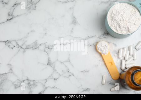 Aminosäurepillen und Pulver auf weißem Marmortisch, flach liegend. Platz für Text Stockfoto