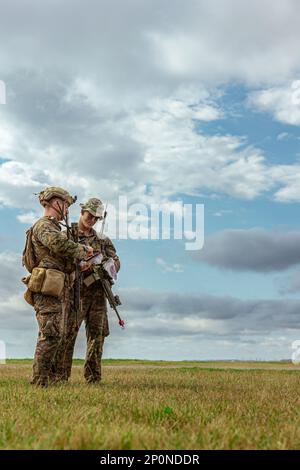USA Marinekorps 1. LT. Sean Conner, Left, und 1. LT. Thomas Cunningham, beide Platoonkommandanten mit Bataillon Landing Team 1/4, 31. Marine Expeditionary Unit, überprüfen ihre Positionen während einer Razzia auf Kin Blue Beach, Okinawa, Japan, 7. Februar 2023. Die Razzia erhöhte die Fähigkeiten der Marines, umkämpfte Gebiete zu sichern und freundlichen Truppen zu ermöglichen, von Schiff zu Küste voranzukommen. Die MEU 31. operiert an Bord von Schiffen der America Amphibious Ready Group im Flottenbereich 7., um die Interoperabilität mit Verbündeten und Partnern zu verbessern und als einsatzbereite Eingreiftruppe zu fungieren Stockfoto