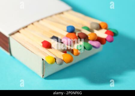 Passt zu bunten Köpfen in der Box auf hellblauem Hintergrund, Nahaufnahme Stockfoto