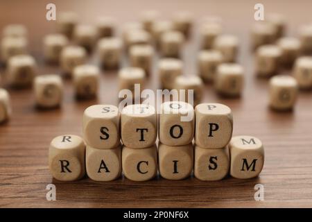 Würfel mit der Phrase "Stop Rassismus" auf einem Holztisch Stockfoto