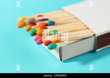 Passt zu bunten Köpfen in der Box auf hellblauem Hintergrund, Nahaufnahme Stockfoto