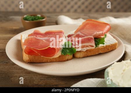 Köstliche Sandwiches mit Frischkäse und Jamon auf einem Holztisch Stockfoto